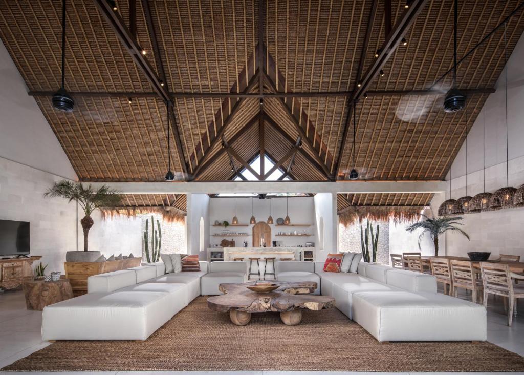 a living room with white couches and a table at Villa Massilia Bali in Seminyak