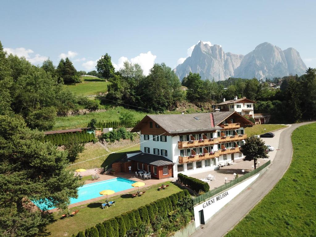 - une vue aérienne sur un complexe avec une piscine dans l'établissement Garni Hotel Melissa, à Castelrotto