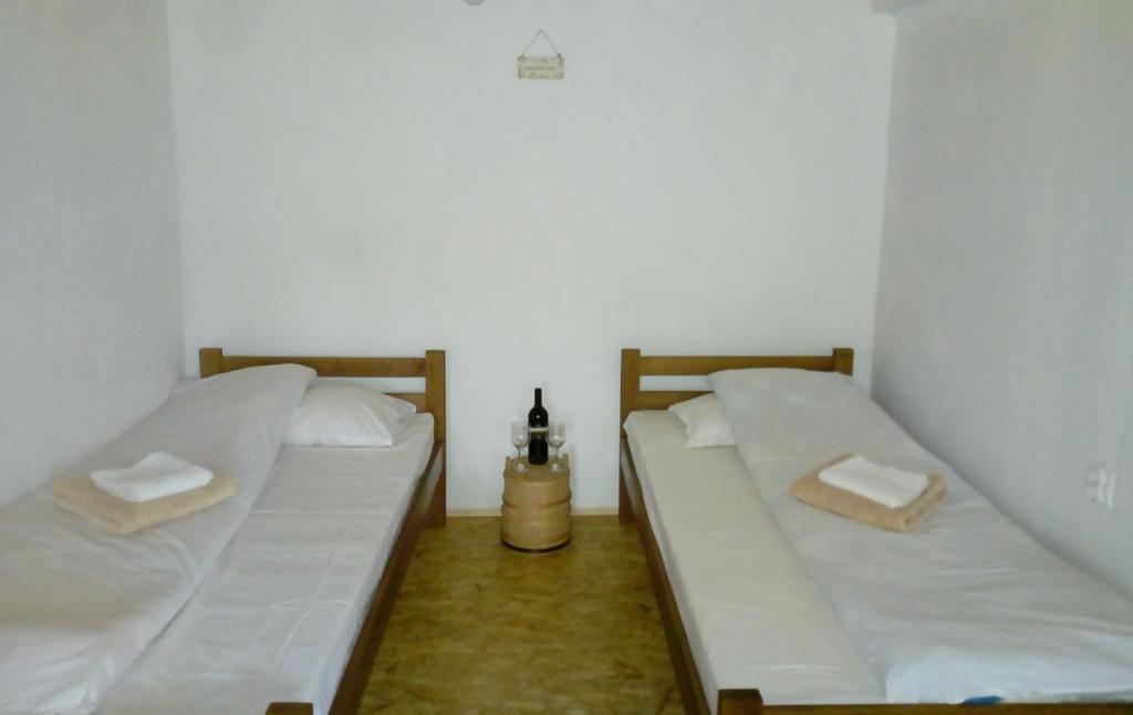 two beds in a room with white walls at Village house Popovic in Žabljak