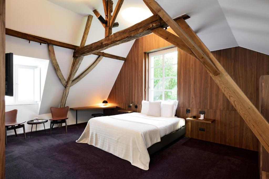 a bedroom with a large white bed and a window at Hotel Messeyne in Kortrijk