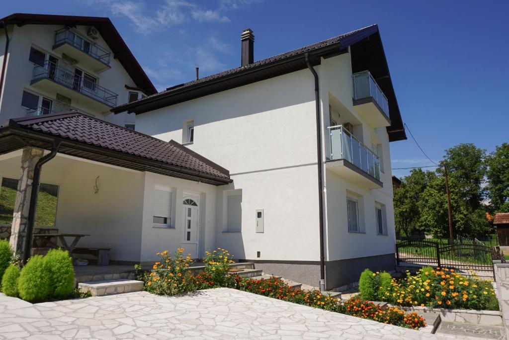 Cette maison blanche dispose d'un balcon et d'une terrasse. dans l'établissement Villa ‘Stone Chair’ in Sarajevo, Vogosca, à Vogošća