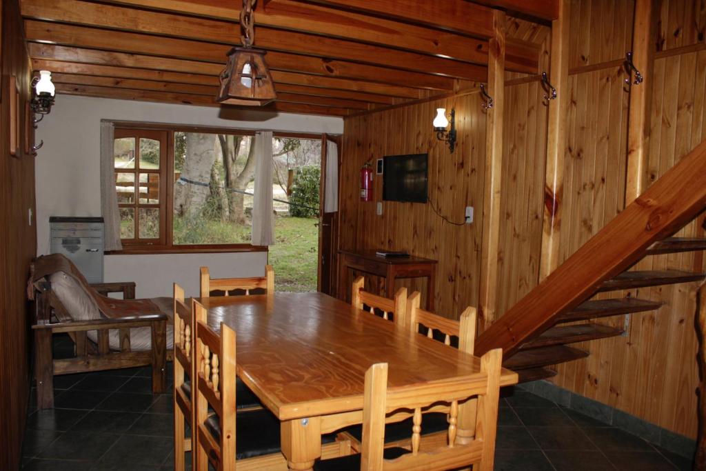uma sala de jantar com uma mesa de madeira e cadeiras em KALENA 4 Playa Bonita DAT em San Carlos de Bariloche