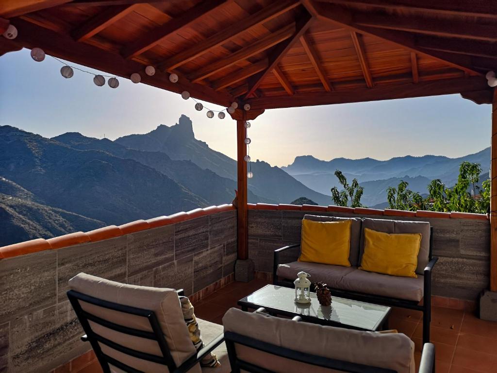 a patio with a table and chairs and a view of mountains at Vivienda Vacacional La Portada in Tejeda
