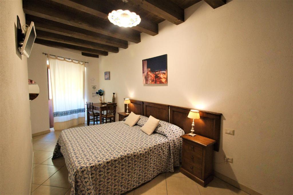 a bedroom with a bed and a table in it at L'Antica Torre Caralis Holiday in Cagliari