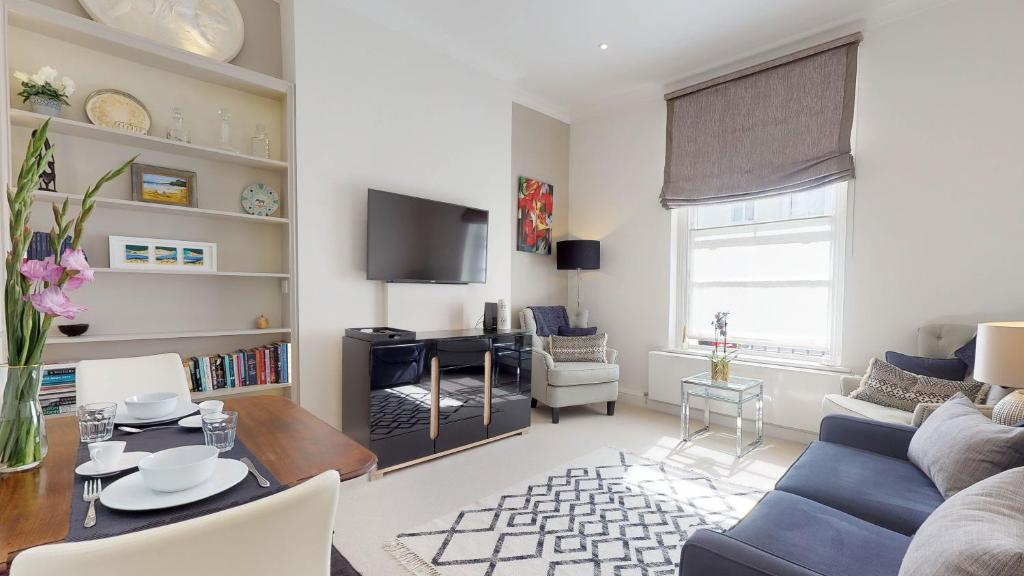 ein Wohnzimmer mit einem Sofa und einem Tisch in der Unterkunft Central London Flat in Westminster in London