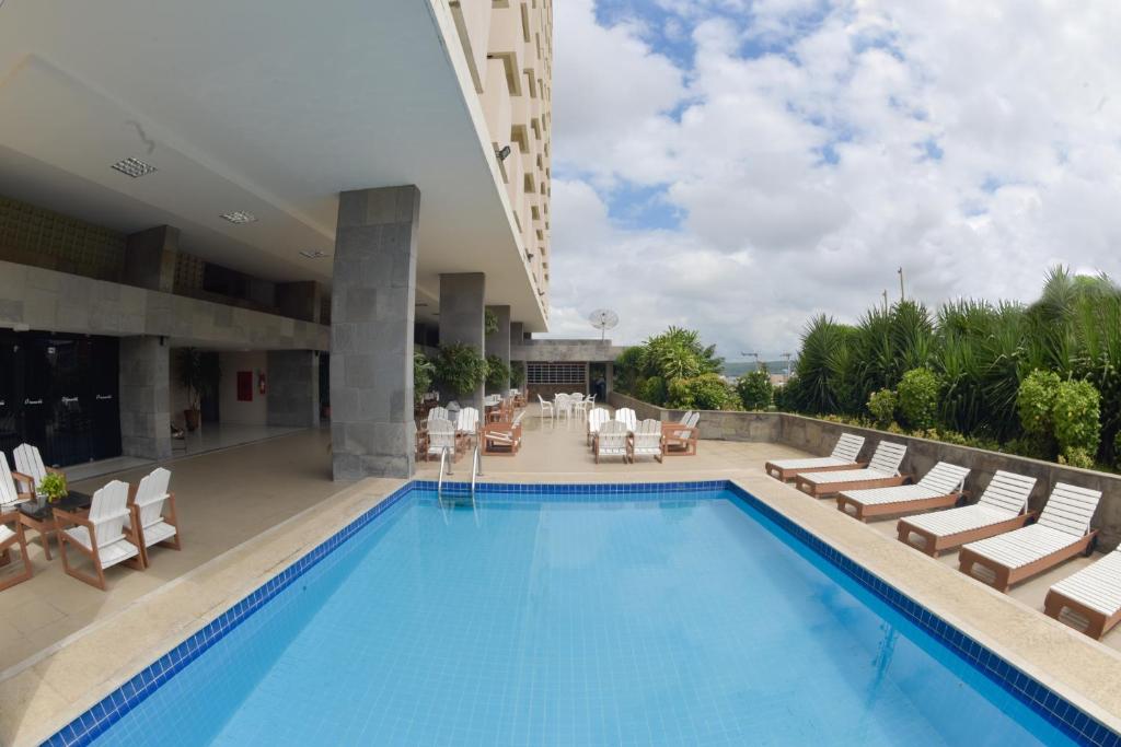 einen Pool mit Liegestühlen und ein Hotel in der Unterkunft Panorama Hotel in Juazeiro do Norte
