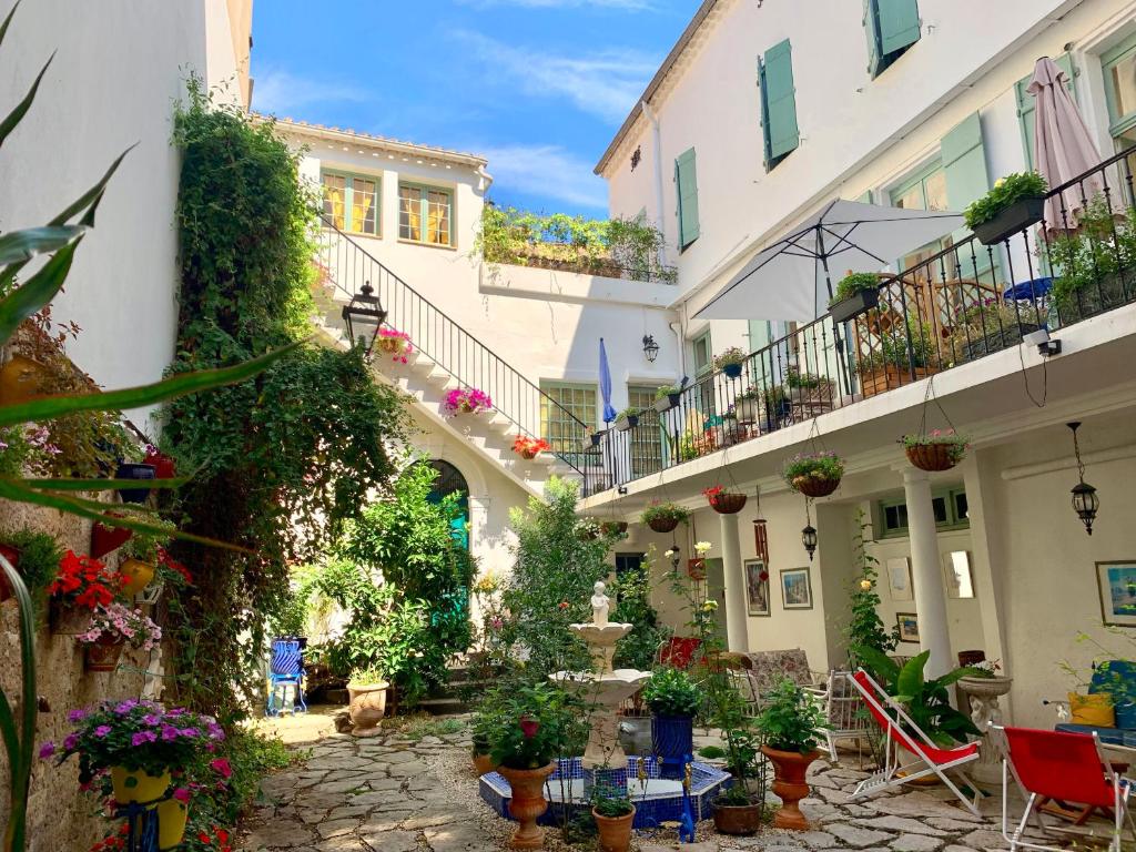 een binnenplaats van een gebouw met potplanten bij Villa Rosa Béziers in Béziers