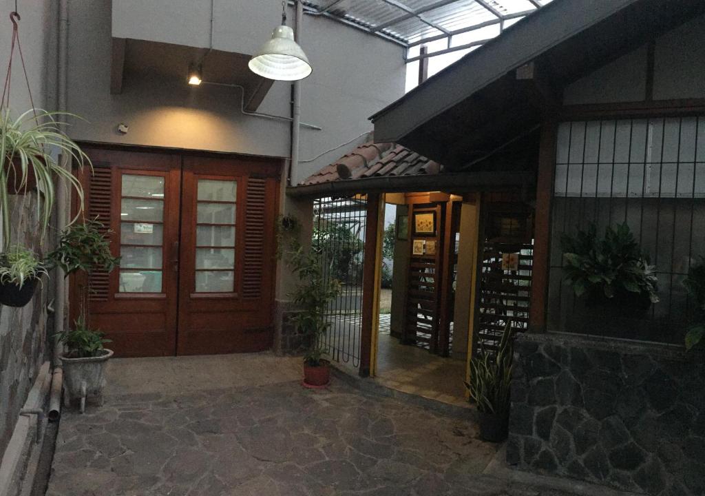 an entrance to a building with a door and plants at De Riau Guesthouse in Bandung