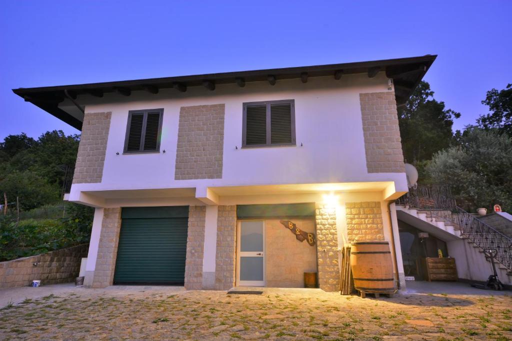 une grande maison blanche avec garage la nuit dans l'établissement Il Convivio Affittacamere, à Rofrano
