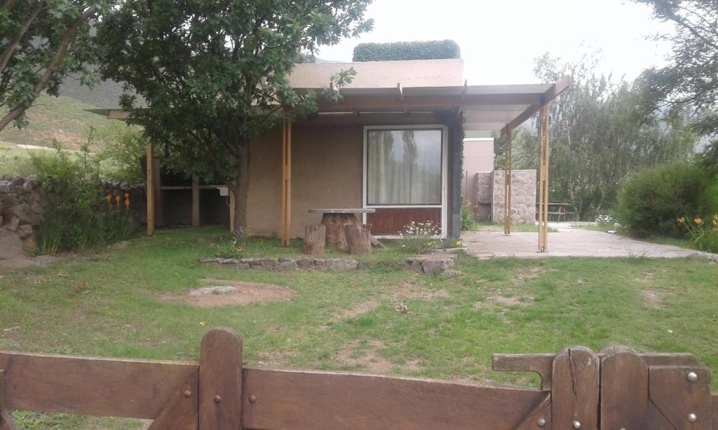 ein kleines Haus mit einer Bank davor in der Unterkunft Casa de Montaña Sacha Huasi in Tafí del Valle