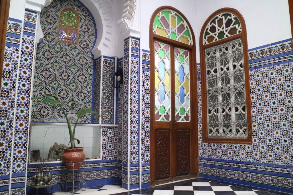 um quarto com azulejos azuis e brancos e uma porta de madeira em Riad Soul of Tetouan em Tétouan