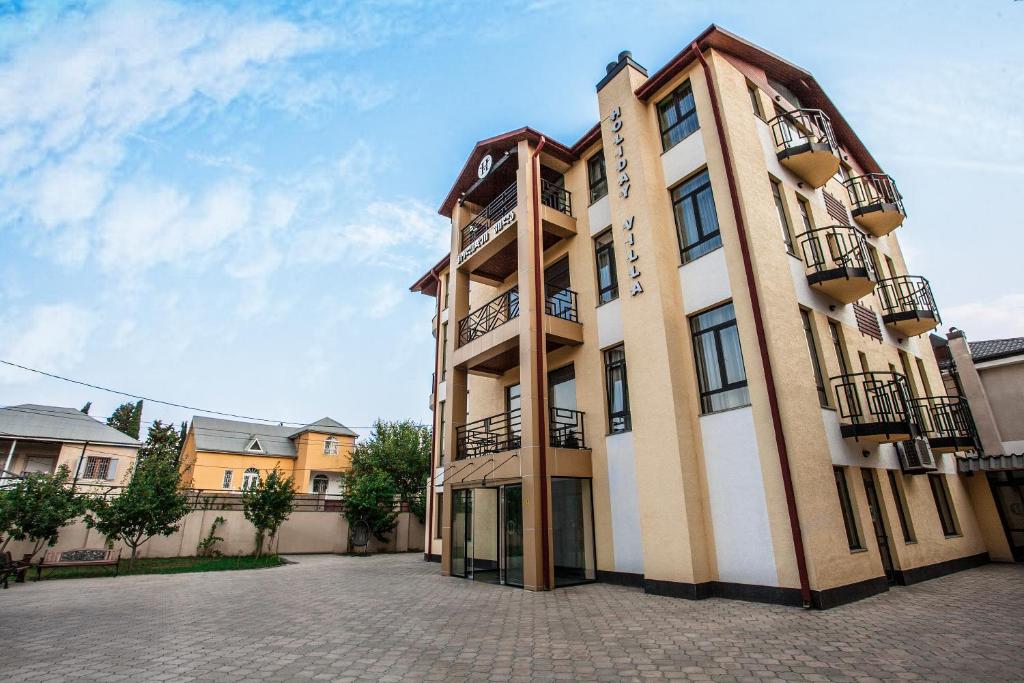 un edificio con balcones en un lateral en Hotel Holiday Villa en Tiflis
