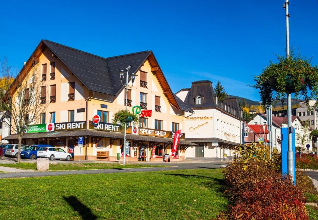 a large building with a black roof on a street at Apartmány Sport with Garage in Rokytnice nad Jizerou