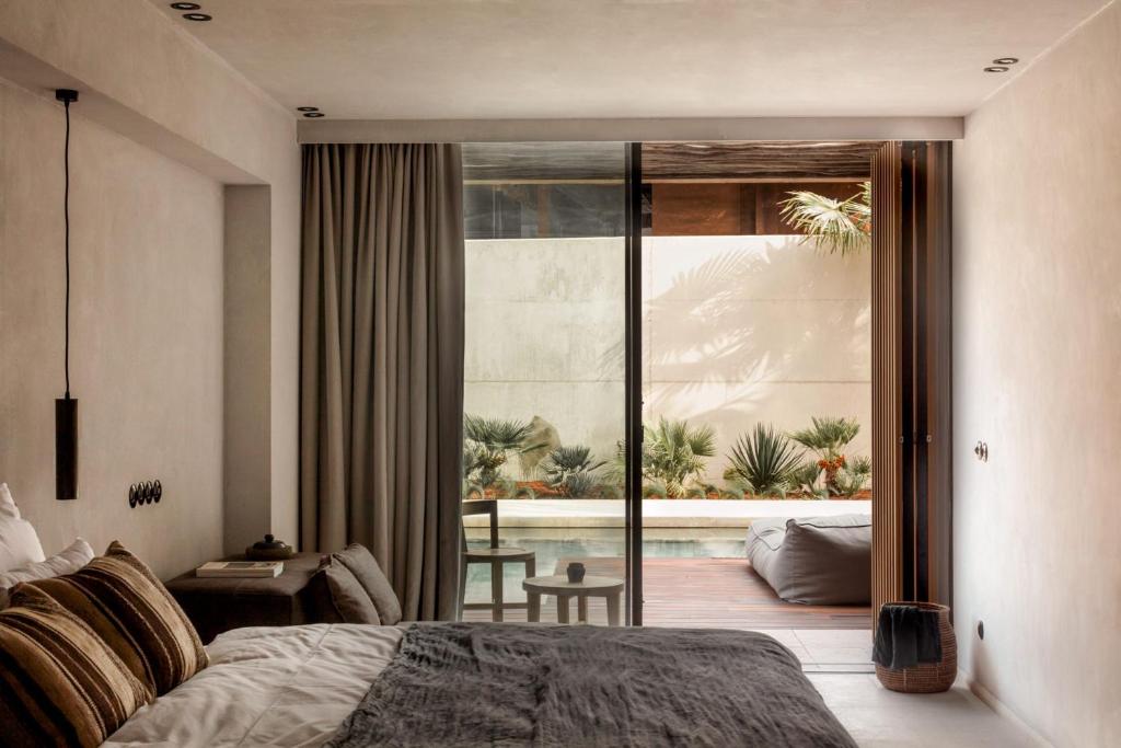 a bedroom with a bed and a view of a patio at OKU Ibiza in San Antonio