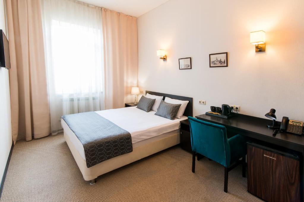 um quarto com uma cama, uma secretária e uma janela em Maksim Gorkiy Hotel em Kazan