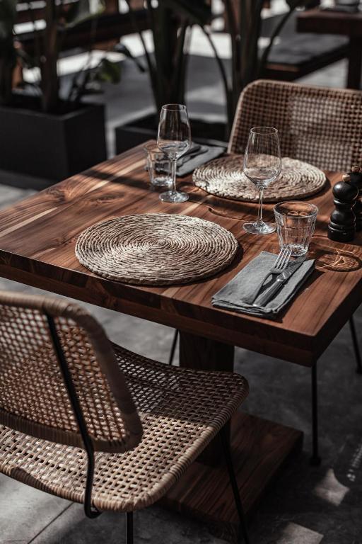 a wooden table with plates and wine glasses on it at OKU Ibiza in San Antonio