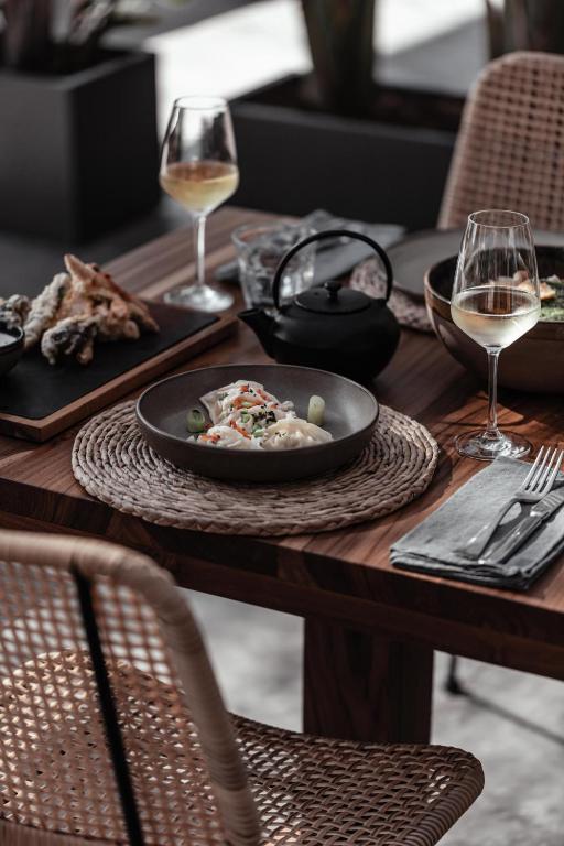 a table with a plate of food and glasses of wine at OKU Ibiza in San Antonio