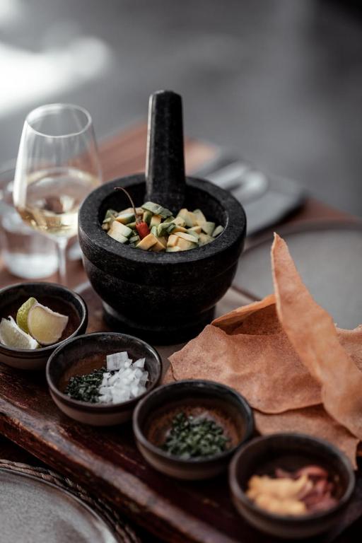 a table with bowls of food and a glass of wine at OKU Ibiza in San Antonio