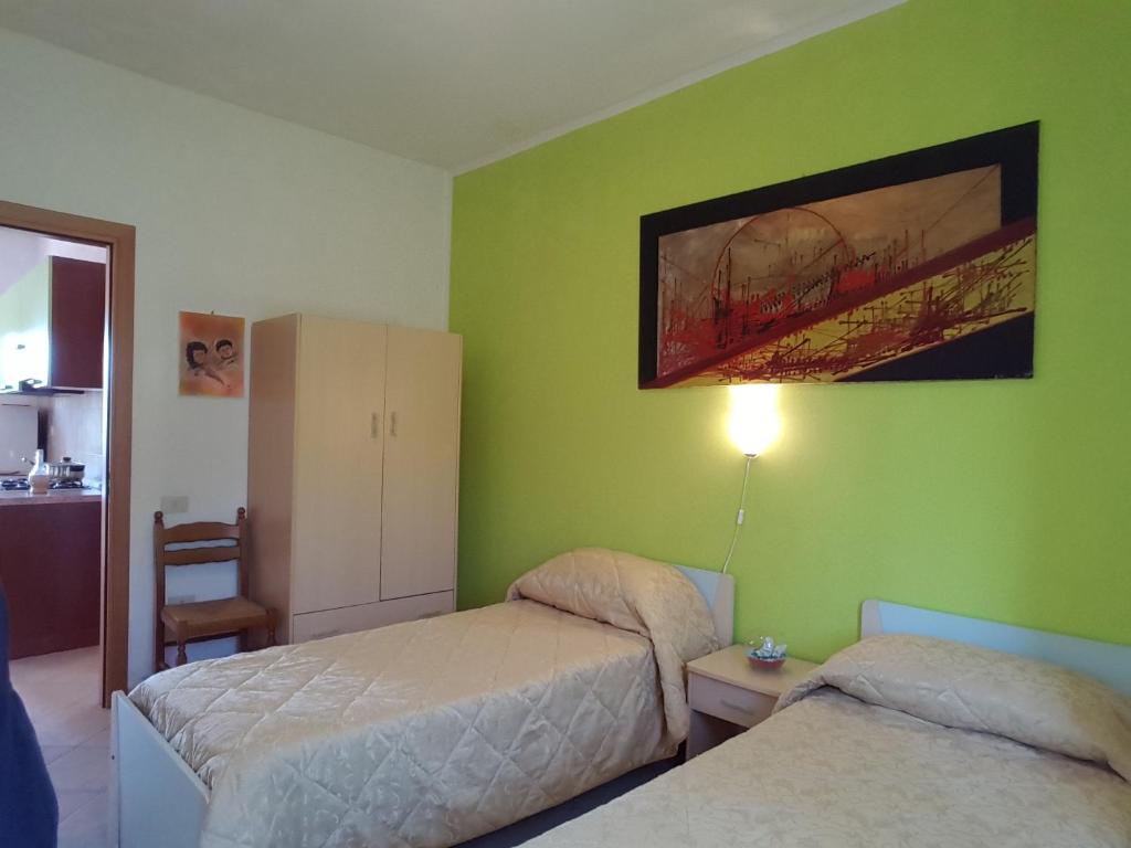 a bedroom with two beds and a green wall at agriturismo heaven in Capo Vaticano