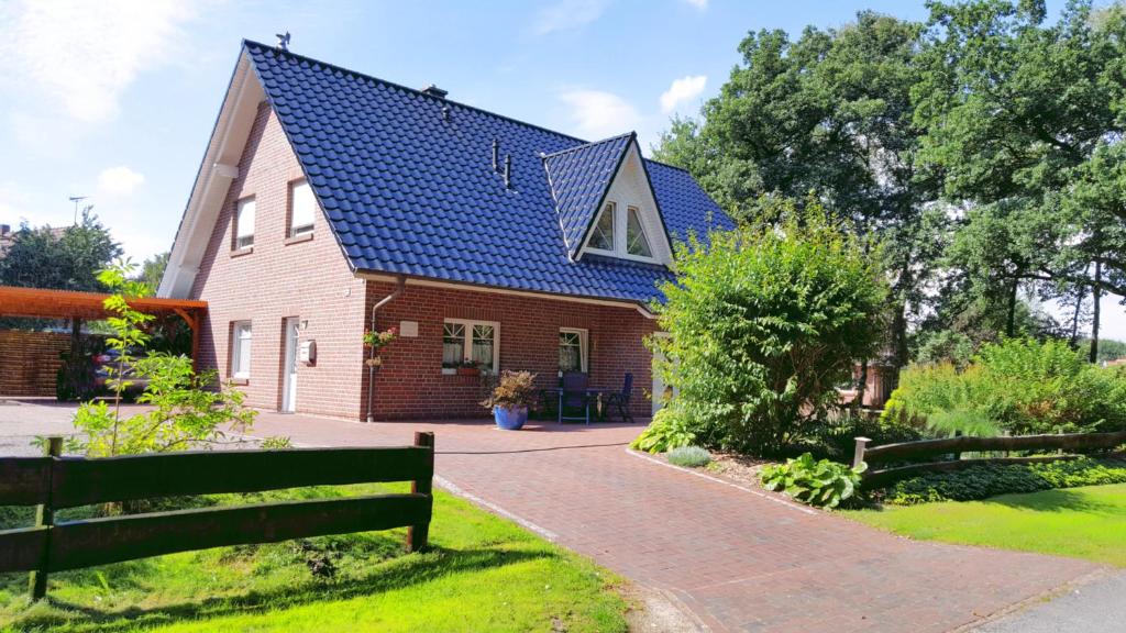 a house with a blue roof and a bench at Ferienwohnung Strudthoff in Ganderkesee