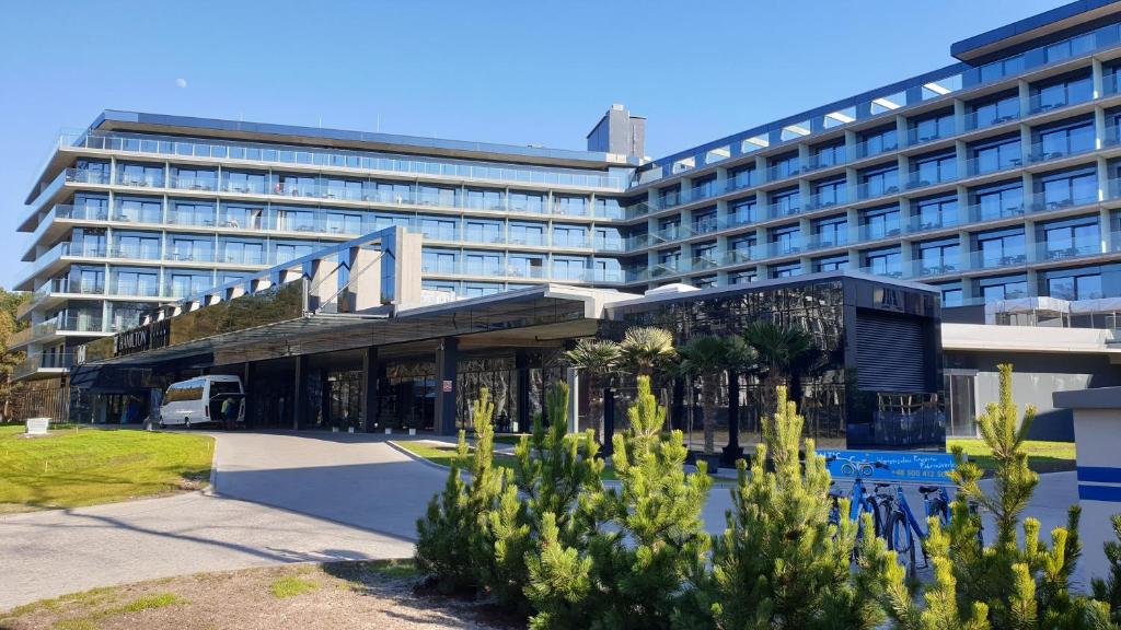 a large building with a bus parked in front of it at Hamilton SPA & Wellness in Świnoujście