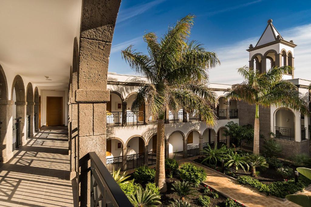 a building with palm trees and a clock tower at Royal Palm Resort & Spa - Adults Only in Playa Jandia