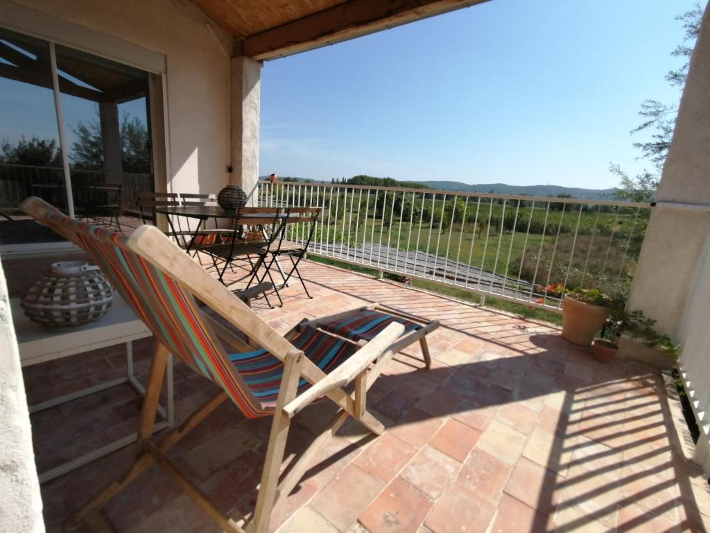 patio con mesa y sillas en el balcón en Domaine Limouzy, en Narbona