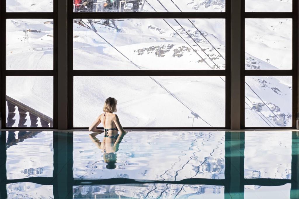 a little boy sitting in a swimming pool in the snow at Résidence Les Balcons de Val Thorens & Spa in Val Thorens