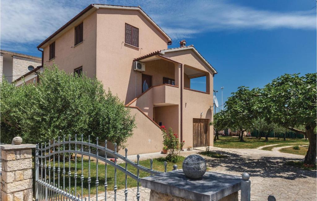 a house with a fence in front of it at Cozy Apartment In Galizana With Kitchen in Galižana