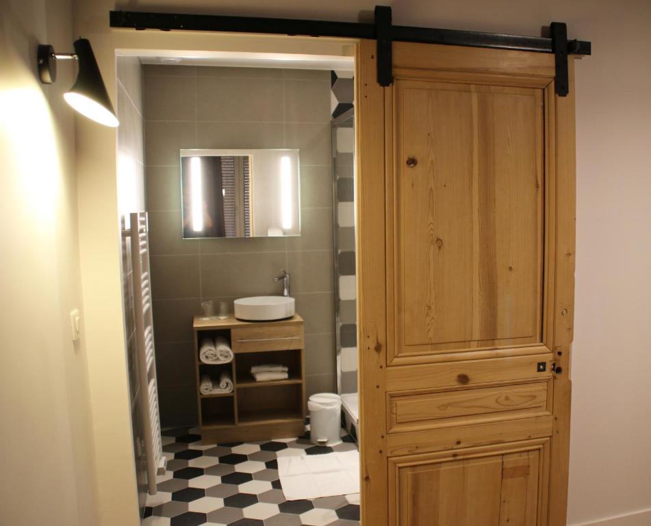 La salle de bains est pourvue d'une armoire en bois et d'un lavabo. dans l'établissement Hotel Saint Vincent, à Lyon