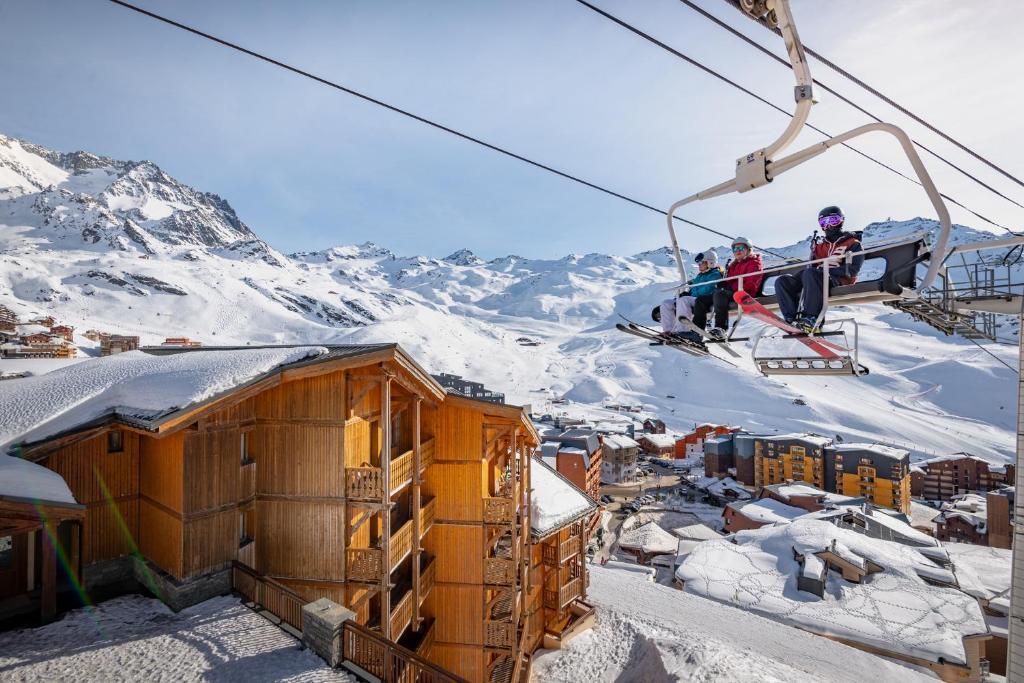 a group of people riding on a ski lift at Résidence Les Balcons de Val Thorens & Spa in Val Thorens