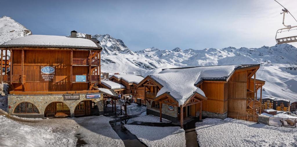 a building with snow on the roof with a ski lift at Résidence Les Balcons de Val Thorens & Spa in Val Thorens