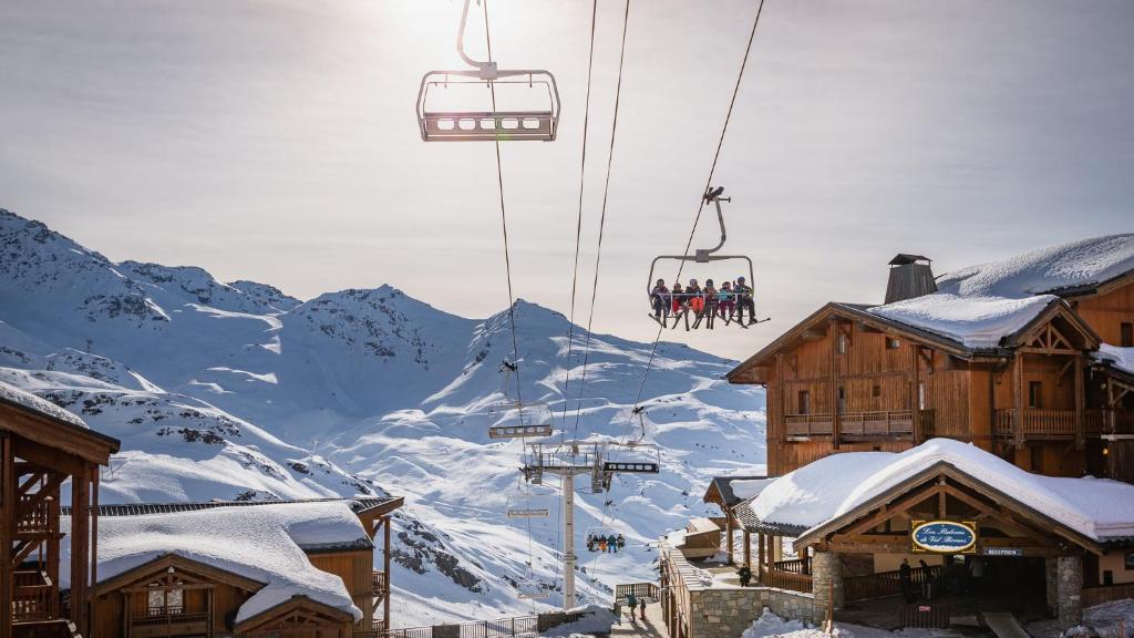 a group of people riding a ski lift over a snow covered mountain at Résidence Les Balcons de Val Thorens & Spa in Val Thorens