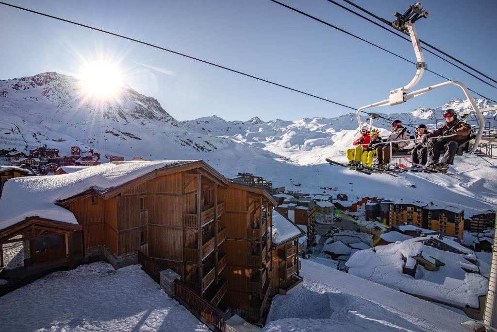 a group of people on a ski lift in the snow at Résidence Les Balcons de Val Thorens & Spa in Val Thorens