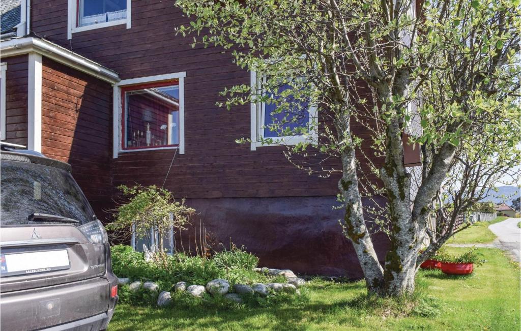 a house with a tree in front of it at Nice Apartment In Giske With 3 Bedrooms And Wifi in Gjuv