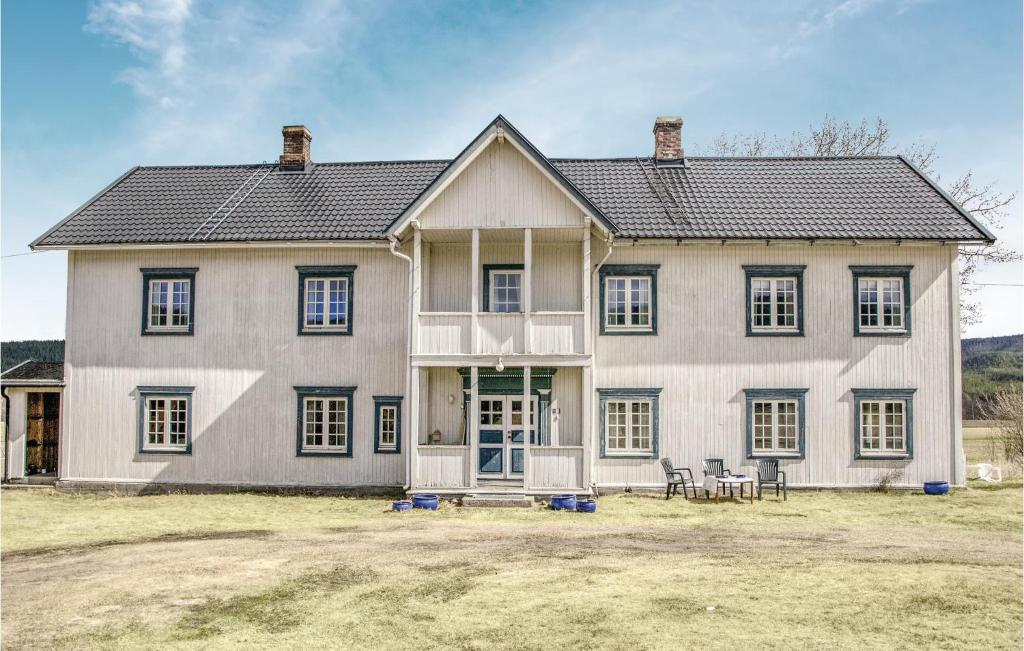 une grande maison blanche avec des fenêtres et des chaises noires dans l'établissement Beautiful Home In Tynset With Kitchen, à Tynset