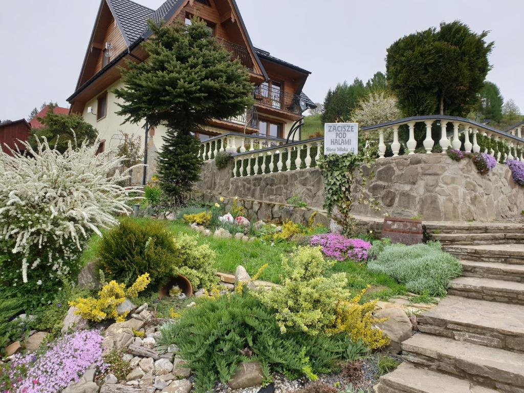 a garden in front of a house with flowers at Zacisze pod Halami in Szlachtowa