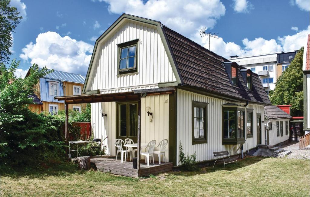 Gorgeous Apartment In Karlskrona With Wifi في كارلسكرونا: منزل أبيض صغير مع شرفة وكراسي