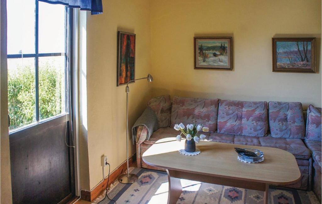 a living room with a couch and a table at Nice Home In Glumslv With 1 Bedrooms in Glumslöv