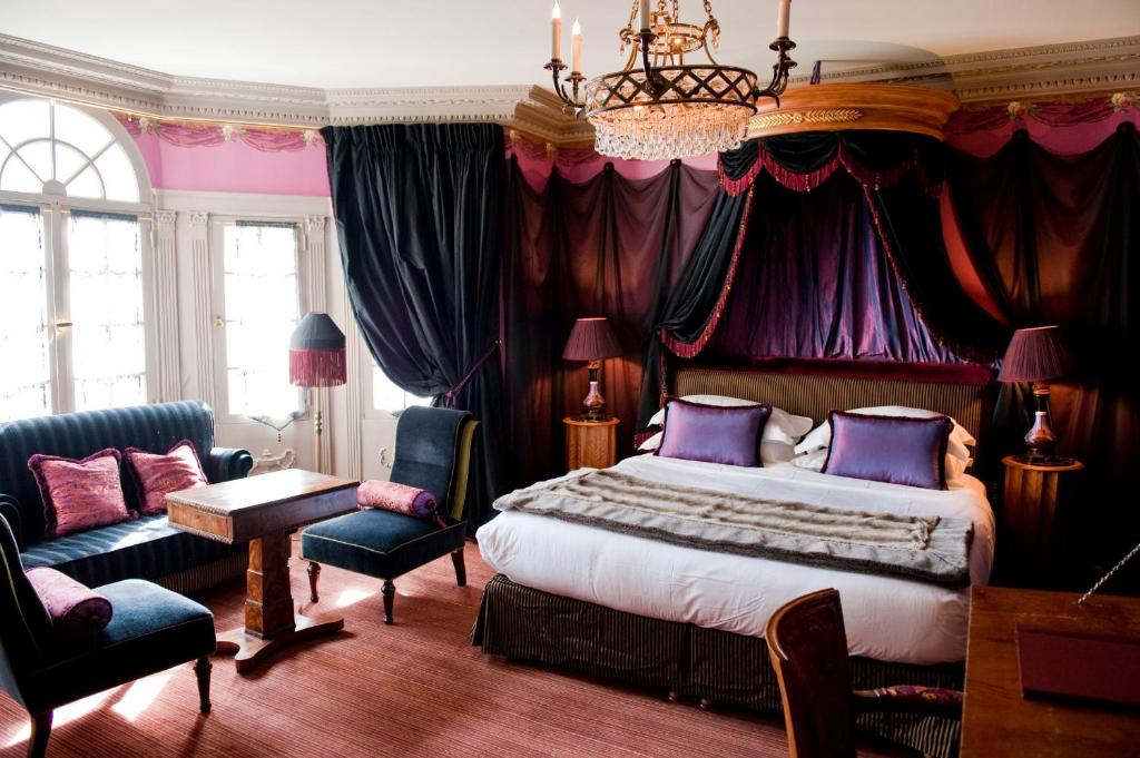 a bedroom with a king sized bed and a chandelier at L'Hôtel in Paris
