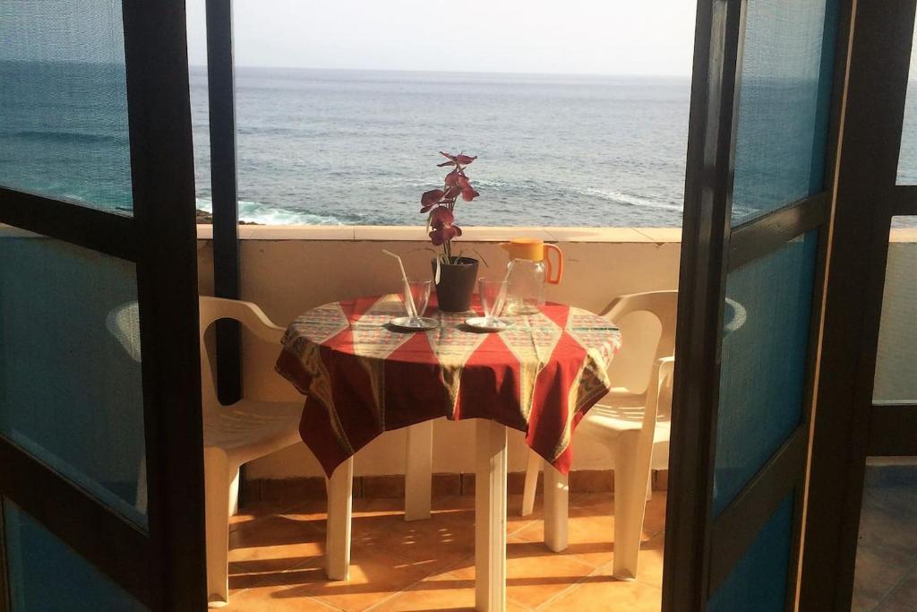 a table with a view of the ocean from a balcony at Couple Getaway with Panoramic Ocean View in Praia