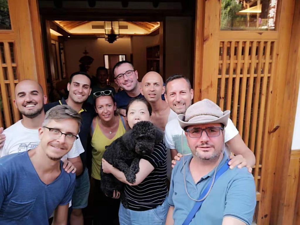 Un gruppo di uomini che posano per una foto con un cane di Yuelu Homestay a Zhangjiajie