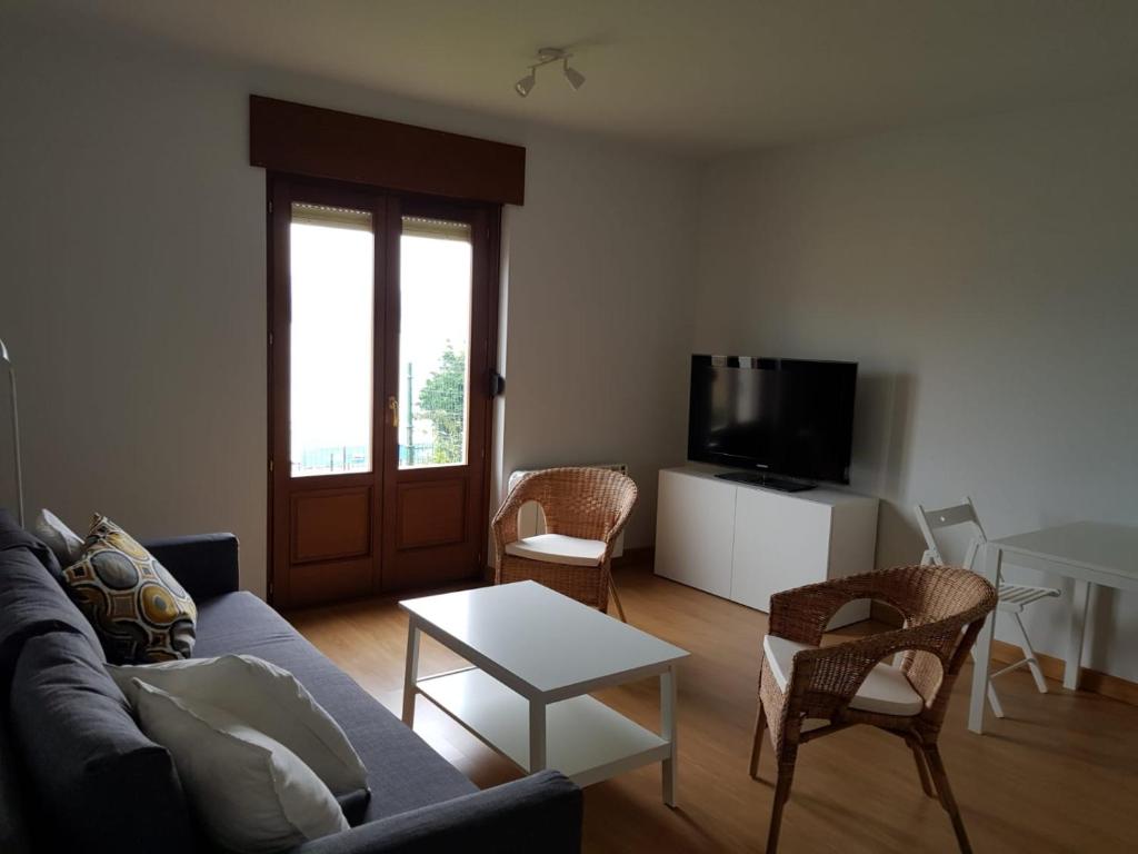 a living room with a couch and a table and a tv at Apartamento en Figueras, Asturias in Castropol