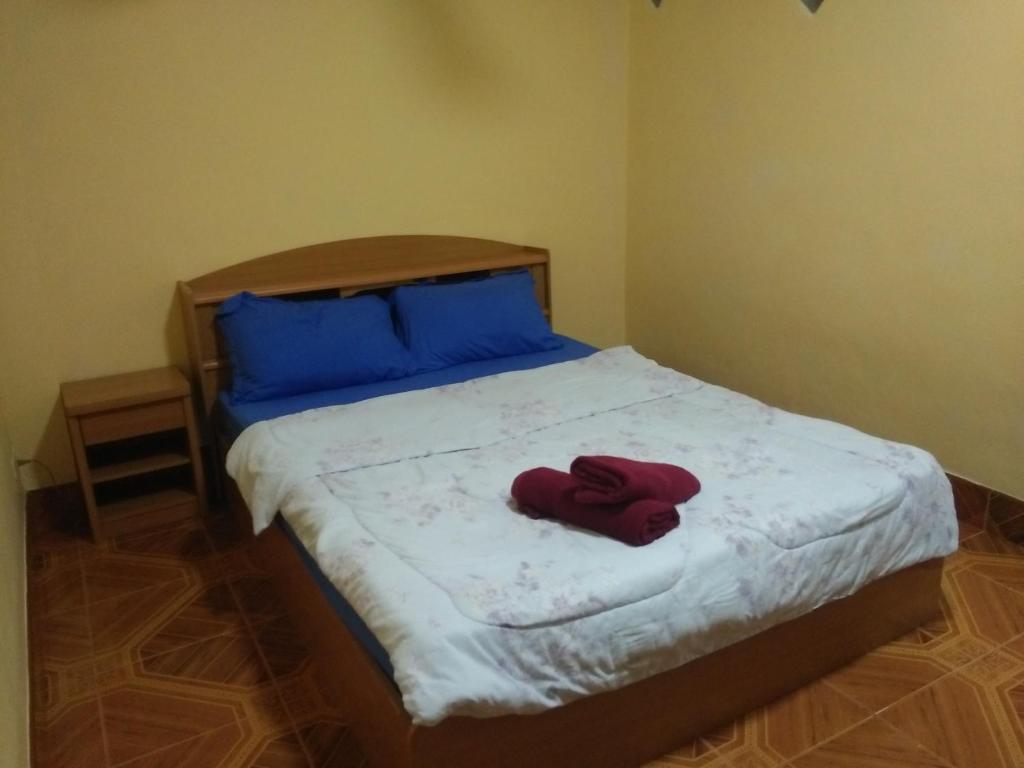 um quarto com uma cama com um roupão vermelho em Inn Lucky em Praia de Jomtien