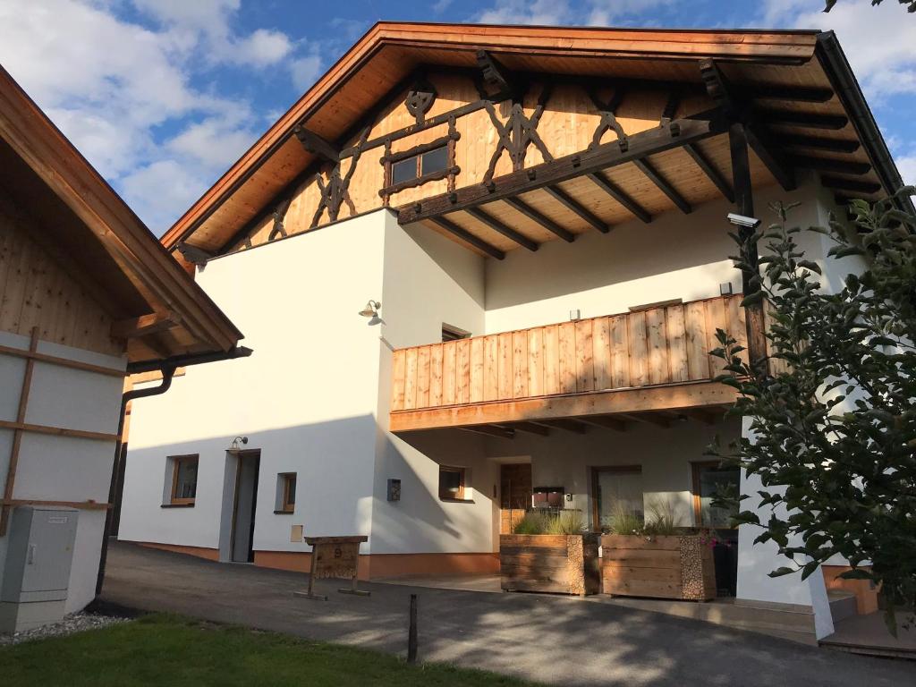 a large white building with a wooden roof at Schusterbrand Appartements in Absam