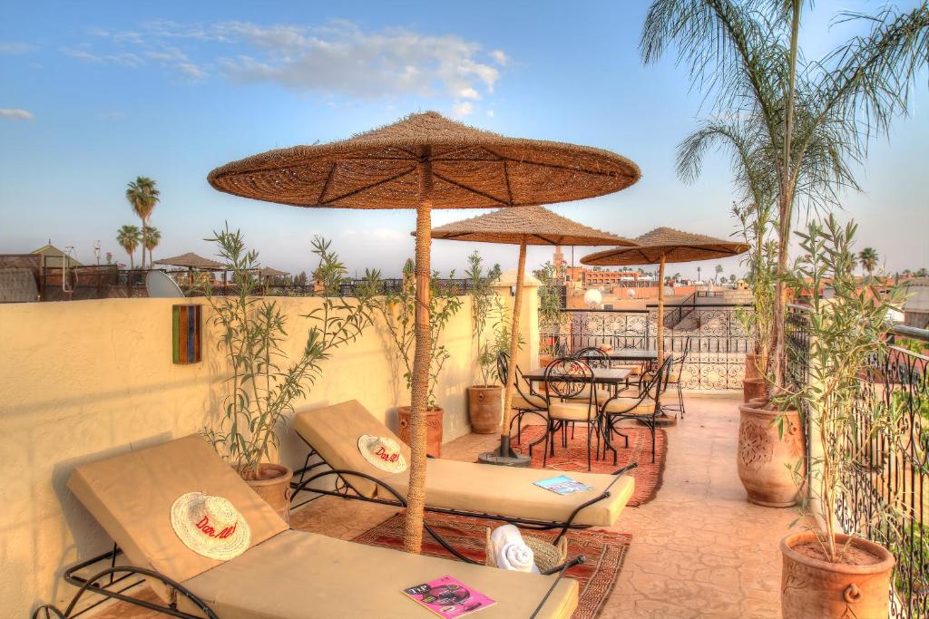 un patio con sombrillas, mesas y sillas en Dar Al Hamra, en Marrakech