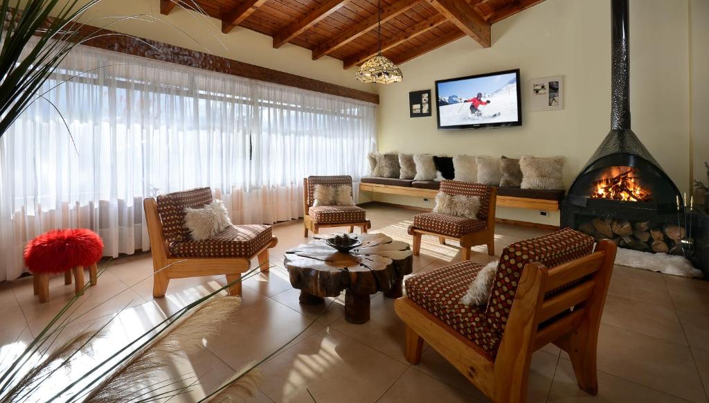 sala de estar con sillas y chimenea en Hotel Aconcagua, en San Carlos de Bariloche