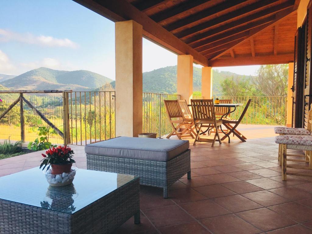 un patio con mesa y sillas y vistas a las montañas en Villa La Vigna, en Domus de Maria