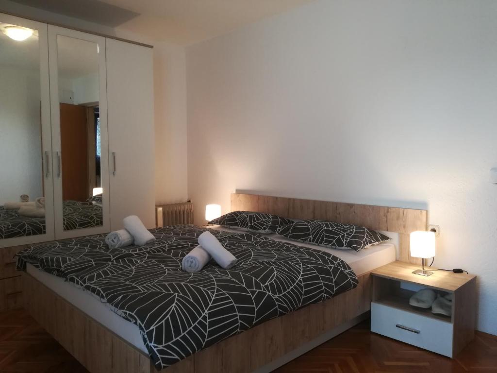 1 dormitorio con 2 camas con almohadas y espejo en Apartman Lidija en Livno