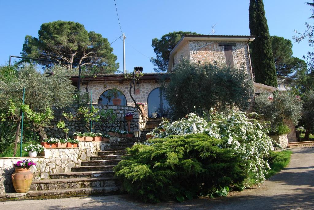 a house with stairs and flowers in front of it at B&B H.M. in Sonnino